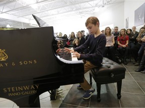 Noah Petrie plays on a $220,000 piano during a recital at the Ottawa Steinway Gallery on Sunday, Dec. 6, 2015. The store is offering its space and pianos for recitals like this at no cost.