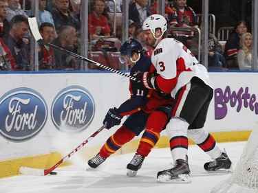 Marc Methot #3 of the Ottawa Senators defends against Jonathan Huberdeau #11 of the Florida Panthers behind the net during first period action.