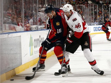 Aleksander Barkov #16 of the Florida Panthers digs the puck out from the boards against  Patrick Wiercioch #46 of the Ottawa Senators.