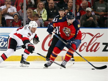 Dmitry Kulikov #7 of the Florida Panthers skates for the puck against Marc Methot #3 of the Ottawa Senators.
