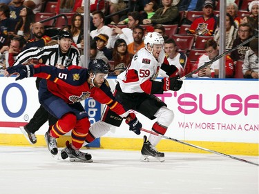 Dave Dziurzynski #59 of the Ottawa Senators skates for possession against Aaron Ekblad #5 of the Florida Panthers.