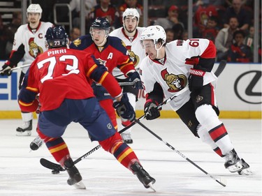 Mark Stone #61 of the Ottawa Senators clears the puck during a penalty kill while being checked by Brandon Pirri #73 of the Florida Panthers.