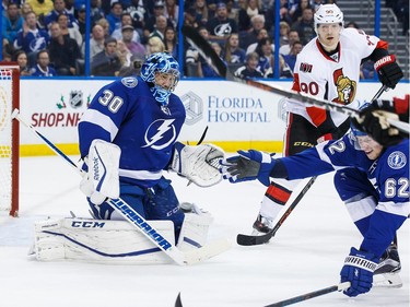 Goalie Ben Bishop #30 and Andrej Sustr #62 of the Tampa Bay Lightning attempt to block a shot against the Ottawa Senators during second period.