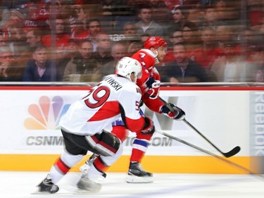 Taylor Chorney #4 of the Washington Capitals skates past David Dziurzynski #59 of the Ottawa Senators in the first period.