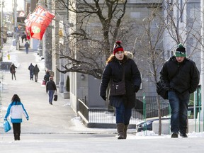 Pedestrians walk along Elgin St. near Laurier St. during a cold snap in Ottawa Monday December 28, 2015.