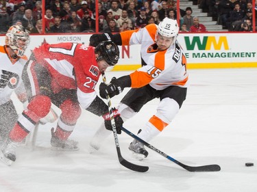 Curtis Lazar #27 of the Ottawa Senators is stopped form getting to a loose puck by the stick-check of Michael Del Zotto #15 of the Philadelphia Flyers.