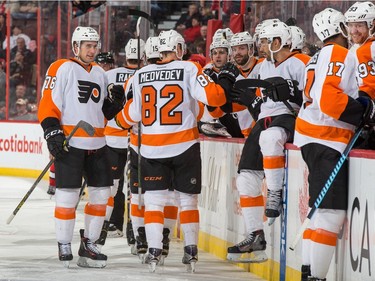 Evgeny Medvedev #82 of the Philadelphia Flyers celebrates his first career NHL goal during a game against the Ottawa Senators with teammates at the players' bench.