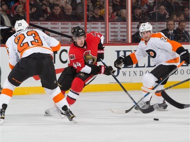 Jean-Gabriel Pageau #44 of the Ottawa Senators stickhandles the puck into the offensive zone against Brandon Manning #23 and Matt Read #24 of the Philadelphia Flyers.