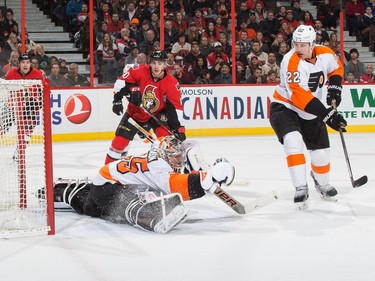 The puck hits the back of the net behind Steve Mason #35 of the Philadelphia Flyers  for a first period goal as Shane Prince #10 of the Ottawa Senators and Luke Schenn #22 look on.