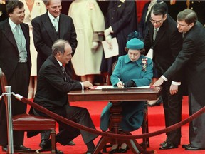 The Queen signs Canada's constitutional proclamation in Ottawa on April 17, 1982 as Prime Minister Pierre Trudeau looks on.