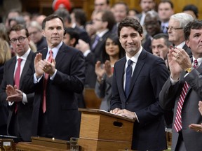 Prime Minister Justin Trudeau receives applauds from the bench after speaking in the House of Commons regarding his party's throne speech, in Ottawa, on Monday, Dec. 7, 2015.
