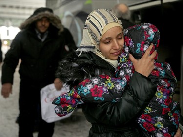 Refugee Kaffa Alwane bundles up her daughter as they meet their first Canadian winter outside the Ottawa airport. A couple of dozen Syrian refugees, who seemed tired but happy,  arrived at Ottawa's airport Tuesday (Dec. 29, 2015) to a welcoming group of volunteers handing out gifts. The group was taken from the airport in a bus to downtown, but not before feeling the chill of the capital's first winter snowstorm.