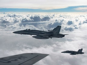 Royal Canadian Air Force CF-18 Hornets depart after refueling with a KC-135 Stratotanker assigned to the 340th Expeditionary Air Refueling Squadron, Thursday, on Oct. 30, 2014, over Iraq.