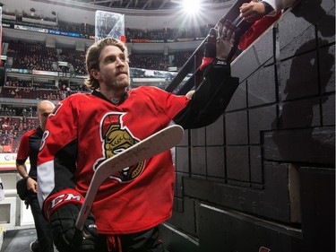 Mike Hoffman #68 of the Ottawa Senators high-fives a fans as he leaves the ice after warmup.