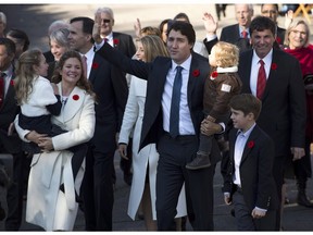 In this Nov. 4, 2015 file photo, Canada's Prime Minister-designate Justin Trudeau, his wife Sophie Gregoire-Trudeau and children Xavier, right, Hadrien, and Ella-Grace, left, walk past crowds to Rideau Hall for Trudeau to be sworn in as prime minister in Ottawa. Trudeau is being criticized by opposition parties for using taxpayer money to pay for two nannies who help to care for his three young children.