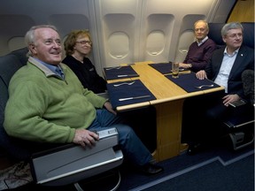 Canadian Prime Minister Stephen Harper speaks with former prime ministers Brian Mulroney, Kim Campbell and Jean Chretien on board a government plane travelling to South Africa Sunday December 8, 2013.
