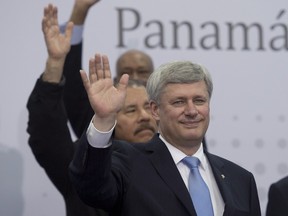 Canadian Prime Minister Stephen Harper and Nicaraguan President Daniel Ortega wave during the offial leaders photo at the Summit of the Americas in Panama City, Panama Saturday April 11, 2015.