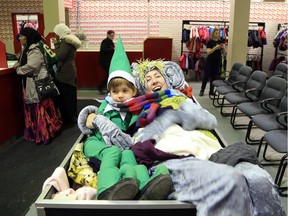 Freezing cast members helped distribute snowsuits at the Snowsuit Fund Depot on Saturday, Dec. 5, 2015. Shellie Simester (Rubble) gives Declan Cassidy (Selfie on the Shelfie) a squeeze as they snuggle up in the bin of clothes.