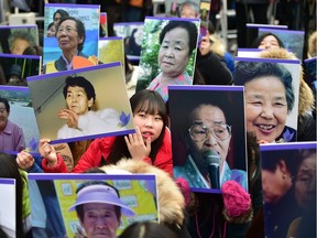 South Korean supporters hold portraits of former "comfort women", who were forced into wartime sexual slavery for Japanese soldiers, during an anti-Japanese rally commemorating the death of nine former sex slaves this year in front of the Japanese embassy in Seoul on December 30, 2015. South Korean "comfort women" and supporters vowed to step up protests against a deal between Seoul and Tokyo on resolving a long-running row over the comfort women.