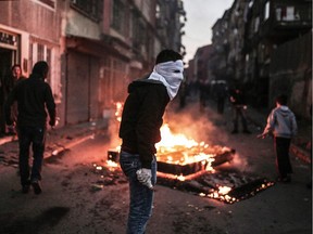 A masked protester holds a petrol bomb during clashes with Turkish police.