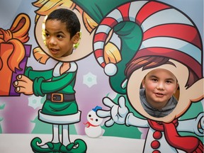 Tyrell Hooper, 7, (L) and Carter Boulet, 8, peer through some cutouts of elves as twenty five police officers participated in CopShop in conjunction with the merchants of Carlingwood Mall by escorting twenty five children as they spent $200 donated to each one of them.