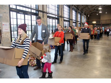 Volunteers helping to pack 700 food hampers on Friday, December 18, 2015, at the Horticulture Building at Lansdowne for the Caring and Sharing Exchange and its annual Christmas Exchange Program. (Caroline Phillips / Ottawa Citizen)