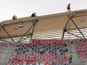 Workers install seats in the south side stands at the TD Place at Lansdowne, home of the Ottawa Redblacks CFL football team, on Thursday, May 29, 2014.