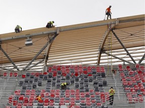 Workers install seats in the south side stands at the TD Place at Lansdowne, home of the Ottawa Redblacks CFL football team, on Thursday, May 29, 2014.