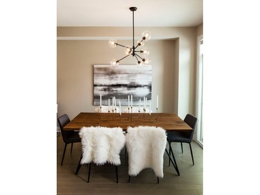 A warm wood dining table with modern chairs covered in fur throws and an impactful, modern light fixture add to the overall modern lodge mix in the Topaz.