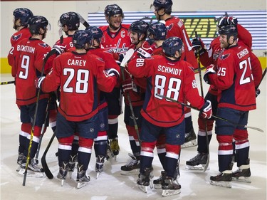 The Washington Capitals swarm the ice around left wing Alex Ovechkin, of Russia, center, in celebration after Ovechkin scored his 500th career NHL goal during the second period of a hockey game against the Ottawa Senators in Washington, D.C., Sunday, Jan. 10, 2016.