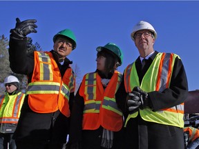 Amarjeet Sohi, Minister of Infrastructure and Communities, left, gestures while Ottawa-Orleans MPP Marie-France Lalonde, center, and Ottawa Mayor Jim Watson, right, look on during a visit to the construction site for the future Tremblay Station, part of the O-Train Confederation Line Light Rail Transit project Wednesday January 13, 2016.