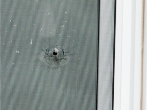 Apparent bullet hole in a second floor window of the unit on Innes Road where a man was shot in the leg as he slept.