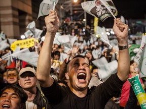 A supporter celebrates at Democratic Progressive Party headquarters in Taipei following the party's victory on Jan. 16. DPP chairwoman Tsai Ing-wen becomes Taiwan's  first female president.