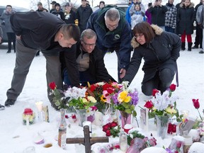 From left, La Loche Mayor Kevin Janvier, lSaskatchewan Premier Brad Wall, federal Public Safety Minister Ralph Goodale and MLA Georgina Jolibois lay flowers at a makeshift memorial at La Loche, Sask., on Sunday. A shooting Friday left four people dead.