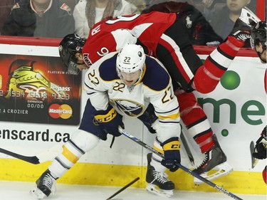 Buffalo Sabres' Johan Larson (22) sends Ottawa Senators' Bobby Rayan (6) into the boards during first period NHL action.
