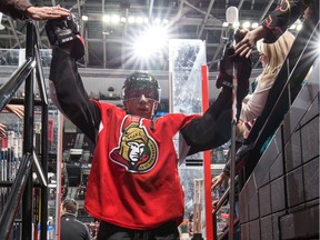 Shane Prince #10 of the Ottawa Senators high-fives fans as he leaves the ice after the warm up.