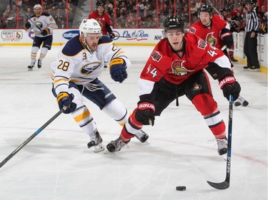 Jean-Gabriel Pageau #44 of the Ottawa Senators controls the puck against Zemgus Girgensons #28 of the Buffalo Sabres.