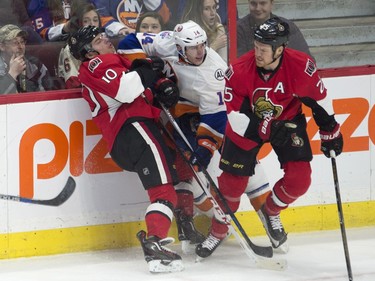 New York Islanders defenseman Thomas Hickey (14) gets his elbow up on Ottawa Senators center Shane Prince (10) as he collides with Senators right wing Chris Neil (25) during first period NHL action.
