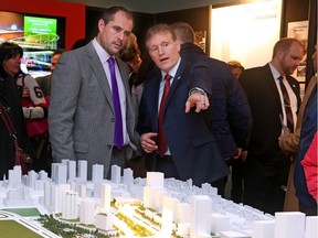 Chris Phillips, left, and Cyril Leeder talk about the scaled model of the Illumination Lebreton redevelopment from the Rendezvous Lebreton group at the War Museum in Ottawa, January 27, 2016.