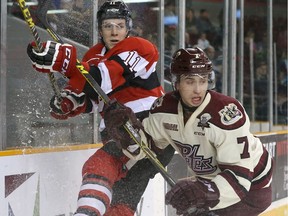 David Pearce of the Ottawa 67's battles for position against Nick Grima of the Peterborough Petes.