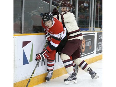 David Pearce #11 of the Ottawa 67's gets checked into the boards by Nick Grima #7 of the Peterborough Petes.