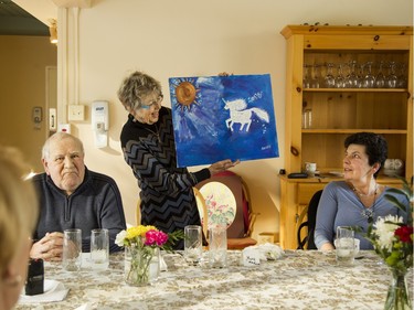 During lunchtime at May Court's day hospice program, art instructor Mary Hardwick shows some of the clients' artistic endeavours.