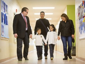 Ecole elementary catholique Principal Francois Dumont, left, shows the Maatouq family around the children's new school in Ottawa, January 14, 2016. The family were part of the first wave of Syrian refugees to come to Canada.