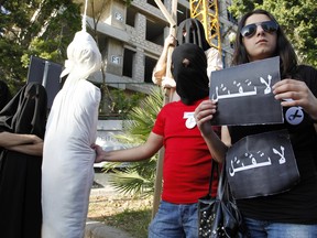 FILE - In this Thursday, April 1, 2010 file photo, activists from a civil organization reenact an execution scene in front of the Saudi Arabia Embassy in Beirut, Lebanon, as they protest a possible beheading of a Lebanese man accused of witchcraft in Saudi Arabia. The Arabic writing on banners read:"don't kill." Saudi Arabia carried out at least 157 executions in 2015, with beheadings reaching their highest level in the country in two decades, according to several advocacy groups that monitor the death penalty worldwide.