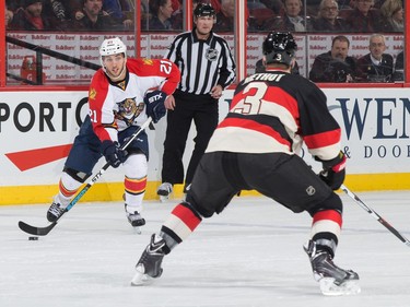 Vincent Trocheck #21 of the Florida Panthers stickhandles the puck across the blue line against Marc Methot #3 of the Ottawa Senators.