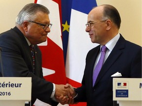 France Interior Minister Bernard Cazeneuve, right, shakes hands with Ralph Goodale, Minister of Public Safety and Emergency Preparedness, at the end of a press conference at Interior ministry, in Paris, Wednesday, Jan. 13, 2016. Cazeneuve and Goodale signed an agreement to strengthen the two countries' partnership in interior security.