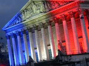 The National Assembly is illuminated with the blue, white and red colors, on July 13, 2014, on the eve of Bastille Day, France's National Day.
