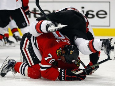 Ottawa Senators defenseman Fredrik Claesson (49) falls over Chicago Blackhawks left wing Dennis Rasmussen (70) during the second period of an NHL hockey game Sunday, Jan. 3, 2016, in Chicago.