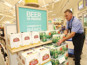 Gilles Barbe, assistant manager of the LCBO on Marcus Drive in Sudbury, Ont., stocks shelves with 12-packs of beer on Friday August 14, 2015. John Lappa/Sudbury Star/Postmedia Network