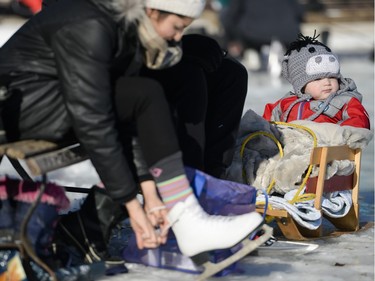 Harison Sinclair (18 months) sits in the sled as his parents put their skates on during the opening day of the Rideau Canal Skateway on Saturday, Jan. 23, 2016.